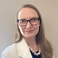 Caroline Sherman - Carroll News | Carroll Publications | Carroll County, MD - Carroll News | Carroll Publications | Carroll County, MD Headshot of a professional woman with glasses, shoulder-length hair, wearing a white blazer and pearl necklace against a neutral background.