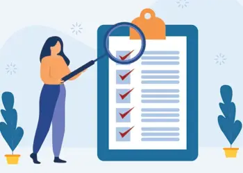 Person standing beside a large clipboard with a checklist and a magnifying glass zooming in on items to review the list for accuracy.