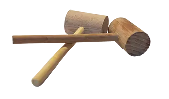 Wooden carpenter's mallet with a long handle and cylindrical head lying across a surface.