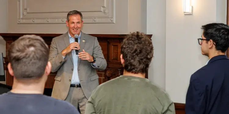 Johnny O Constitution Day_FeaturedImage - Carroll News | Carroll Publications | Carroll County, MD Man in a gray suit speaks into a microphone to a small audience in a conference room