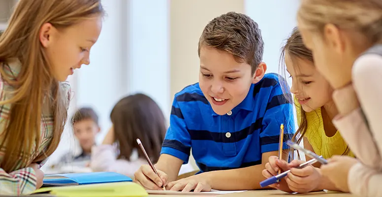 carroll-news-ccps-image - Carroll News | Carroll Publications | Carroll County, MD Group of four kids sit at a table, writing and drawing together in a bright classroom, smiling and helping each other on a project.