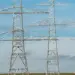 power-lines-carroll-county - Carroll News | Carroll Publications | Carroll County, MD Metal lattice transmission towers carrying high‑voltage lines across a flat field under a blue sky.